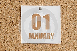 january 01. 01th day of the month, calendar date.White calendar sheet attached to brown cork board.Winter month, day of