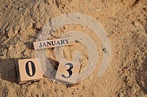 January 03, Number cube with Sand background.