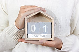 January 1 in the calendar. the girl is holding a wooden calendar. New Year. World Day of Peace. Feast of Mary