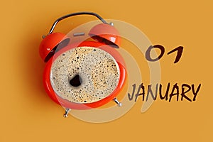 January 1 calendar: orange clock shaped coffee mug, name of the month january, numbers 01, yellow background, top view