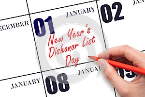 January 1. Hand writing text New Year's Dishonor List Day on calendar date. Save the date.