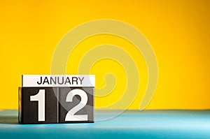 January 12th. Day 12 of january month, calendar on yellow background. Winter time. Empty space for text
