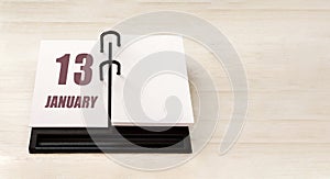 january 13. 13th day of month, calendar date. Stand for desktop calendar on beige wooden background. Concept of day of