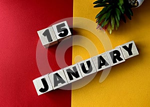 January 15 in black letters on wooden blocks on a divided yellow-red background .