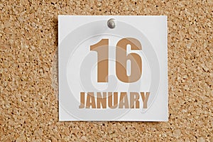 january 16. 16th day of the month, calendar date.White calendar sheet attached to brown cork board.Winter month, day of