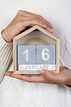 January 16 in the calendar. the girl is holding a wooden calendar. The Beatles Day