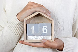 January 16 in the calendar. the girl is holding a wooden calendar. The Beatles Day