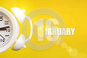 January 16th. Day 16 of month, Calendar date. White alarm clock on yellow background with calendar day. Winter month, day of the