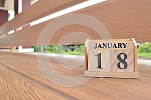 January 18, Number cube with wooden balcony background.