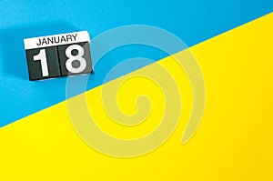 January 18th. Day 18 of january month, calendar on blue and yellow background flat lay, top view. Winter time. Empty