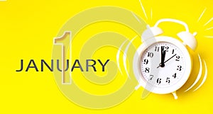 January 1st . Day 1 of month, Calendar date. White alarm clock with calendar day on yellow background. Minimalistic concept of