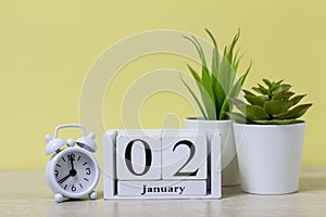 January 2 on a wooden calendar next to the alarm clock is the date of the beginning of the new month and new year