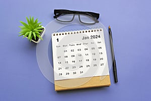 January 2024 desk calendar on blue background.