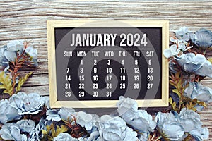 January 2024 monthly calendar with flower bouquet decoration on wooden background