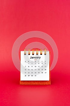 January 2024 white mini desk calendar on red background