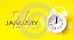 January 24th. Day 24 of month, Calendar date. White alarm clock with calendar day on yellow background. Minimalistic concept of