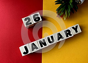 January 26 in black letters on wooden blocks on a divided yellow-red background .