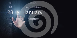 January 28th. Day 28 of month, Calendar date. Hand click luminous icon PLAY and DATE on dark blue background. Winter month, day of