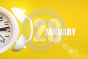 January 28th. Day 28 of month, Calendar date. White alarm clock on yellow background with calendar day. Winter month, day of the