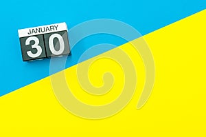 January 30th. Day 30 of january month, calendar on blue and yellow background flat lay, top view. Winter time. Empty