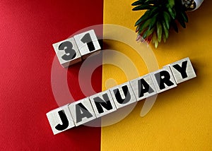 January 31 in black letters on wooden blocks on a divided yellow-red background .