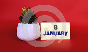 January 8  on a yellow sticker.Next to it is a pot with a flower on a red background .