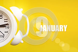 January 9th. Day 9 of month, Calendar date. White alarm clock on yellow background with calendar day. Winter month, day of the