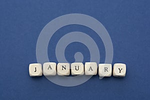 January lettering. Wooden blocks with january word over clasic blue blackground. Copy space photo