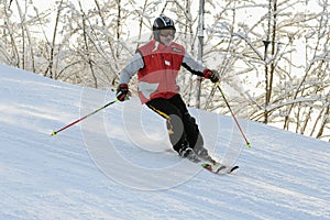 Elderly man skiing down ski slope