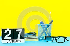 January 27th. Day 27 of january month, calendar on yellow background with office supplies. Winter time