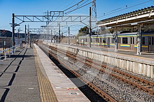 Japan, Beautiful view of Japanese railway train track, empty platform and local train in the background