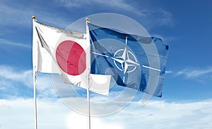 Japan flag and Atlantic Treaty Organization flag on cloudy sky. waving in the sky