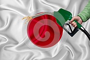 JAPAN flag Close-up shot on waving background texture with Fuel pump nozzle in hand. The concept of design solutions. 3d rendering