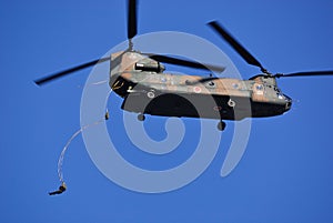 Japan Ground Self Defense Force paratroopers jump out the back of a CH-47J Chinook heavy-lift helicopter.