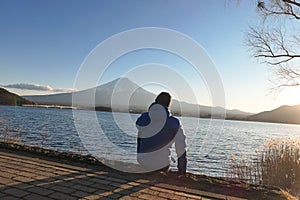 Japan - A man sitting at the Kawaguchiko Lake side and watching Mt Fuji