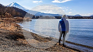 Japan - A man standing at the side of Kawaguchiko Lake with the view on Mt Fuji