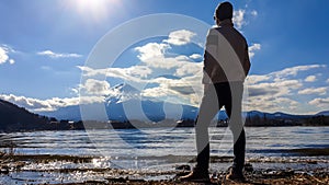 Japan - A man standing at the side of Kawaguchiko Lake with the view on Mt Fuji