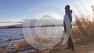 Japan - A man standing at the side of Kawaguchiko Lake with the view on Mt Fuji