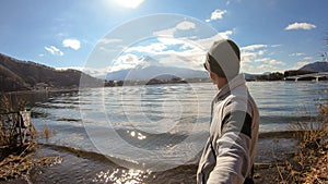 Japan - A man standing at the side of Kawaguchiko Lake with the view on Mt Fuji