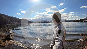 Japan - A man standing at the side of Kawaguchiko Lake with the view on Mt Fuji