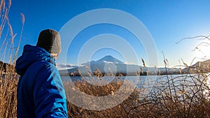 Japan - A man standing at the side of Kawaguchiko Lake with the view on Mt Fuji