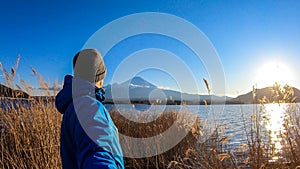 Japan - A man standing at the side of Kawaguchiko Lake with the view on Mt Fuji