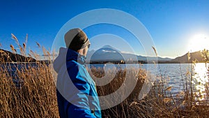 Japan - A man standing at the side of Kawaguchiko Lake with the view on Mt Fuji