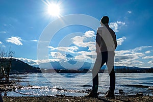 Japan - A man standing at the side of Kawaguchiko Lake with the view on Mt Fuji