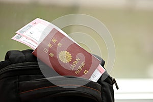 Japan passport with airline tickets on touristic backpack close up. Tourism and travel