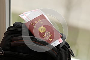 Japan passport with airline tickets on touristic backpack close up. Tourism and travel