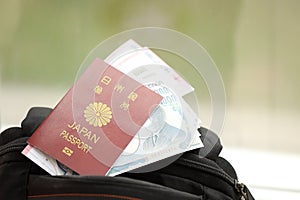 Japan passport with japanese yen money bills with airline tickets on backpack