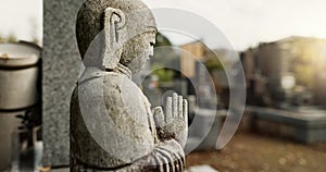 Japan, prayer hands and buddhist stone statue at graveyard for spiritual religion in Tokyo. Jizo, cemetery and