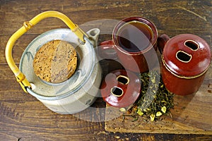 Japan's teapot and cups with green tea on wooden plank