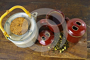 Japan's teapot and cups with green tea on wooden plank